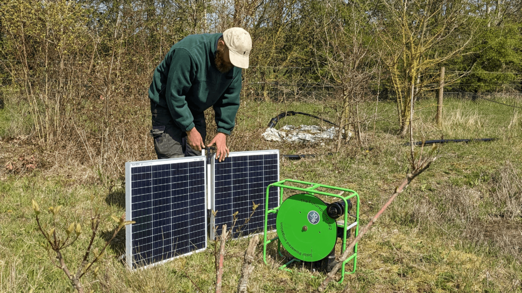 Farmer setting up solar panels for irrigation pump