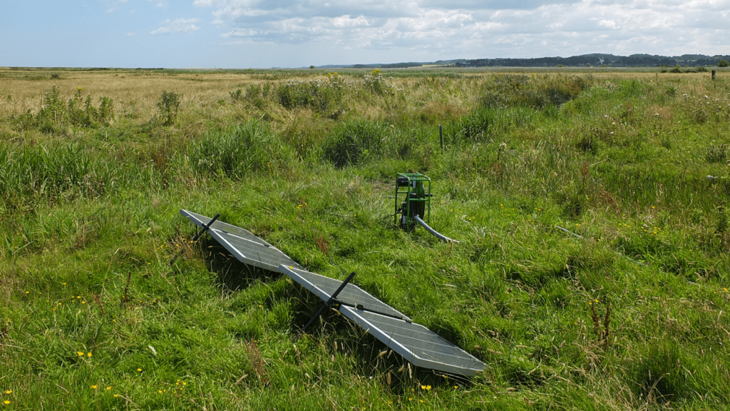 The Futrepump SF2 solar pump with two 120W panels set up in the grass on the marshland