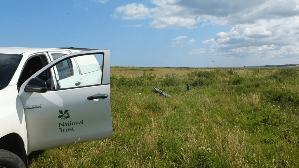 National Trust van next to a Futurepump solar pump hidden in the grass on the marshland